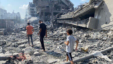 Palestinians inspect the damage following an Israeli airstrike on the El-Remal area in Gaza City